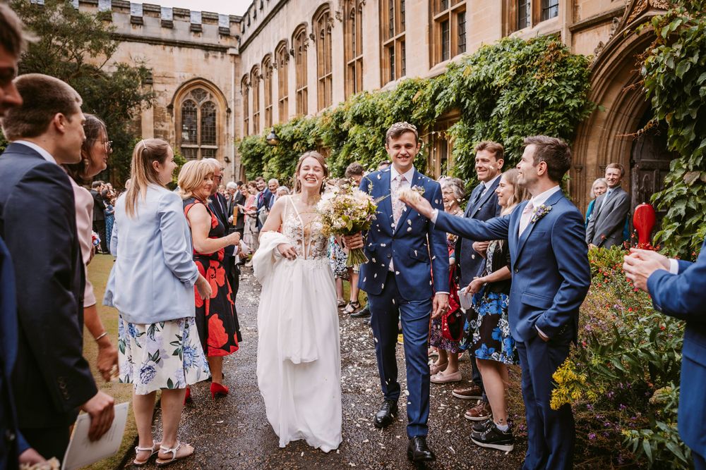 Wedding party celebrates in historic courtyard surrounded by stone architecture at Balliol College, Oxford