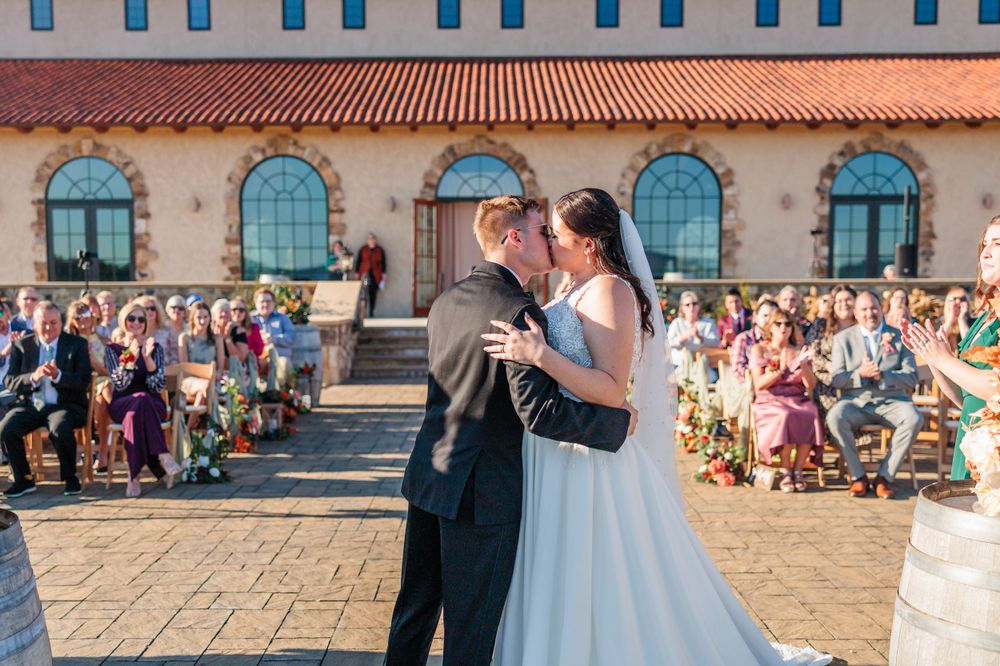 Wedding ceremony at Mediterranean-style venue with terra cotta roof and arched windows.