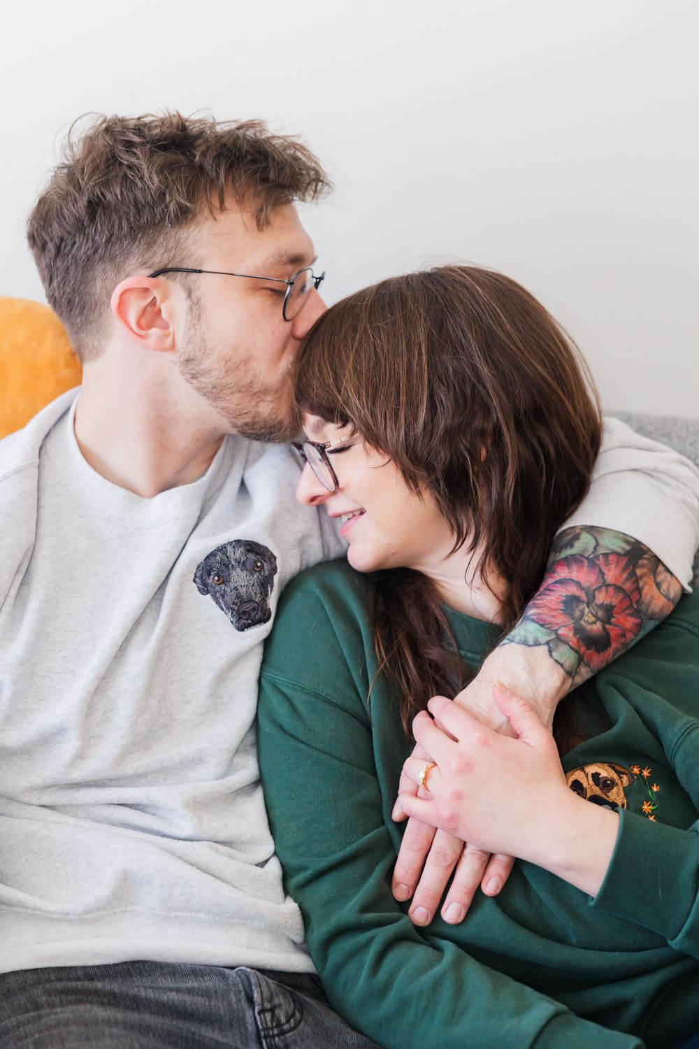 Intimate moment shared between couple in casual wear on couch.