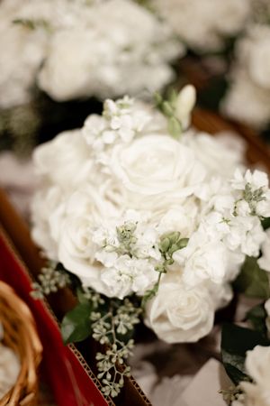 Beautiful wedding bouquet of white roses and delicate flowers with green foliage for bridal arrangement.