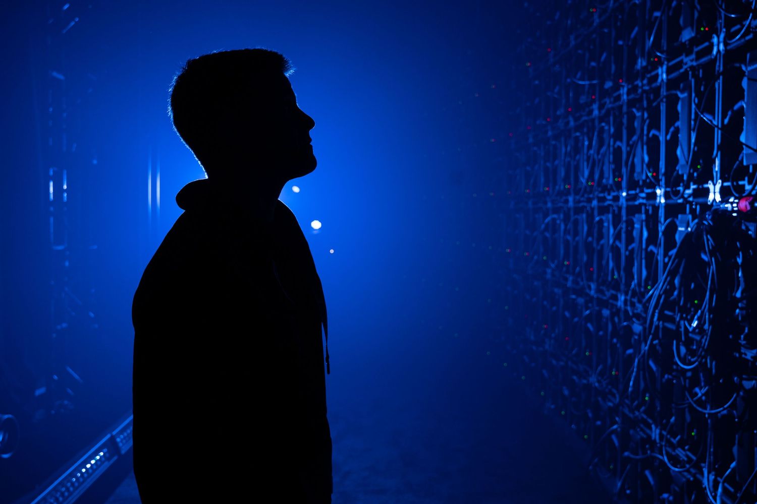 Silhouette of Russell Brunson standing backstage at FHL with a glowing blue light before the video wall raises for him to take the stage