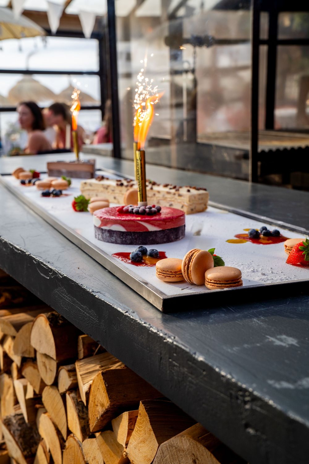 Elegante presentatie van bruiloftsdesserts met bessentaart, macarons en sterretjes op een marmeren ondergrond.