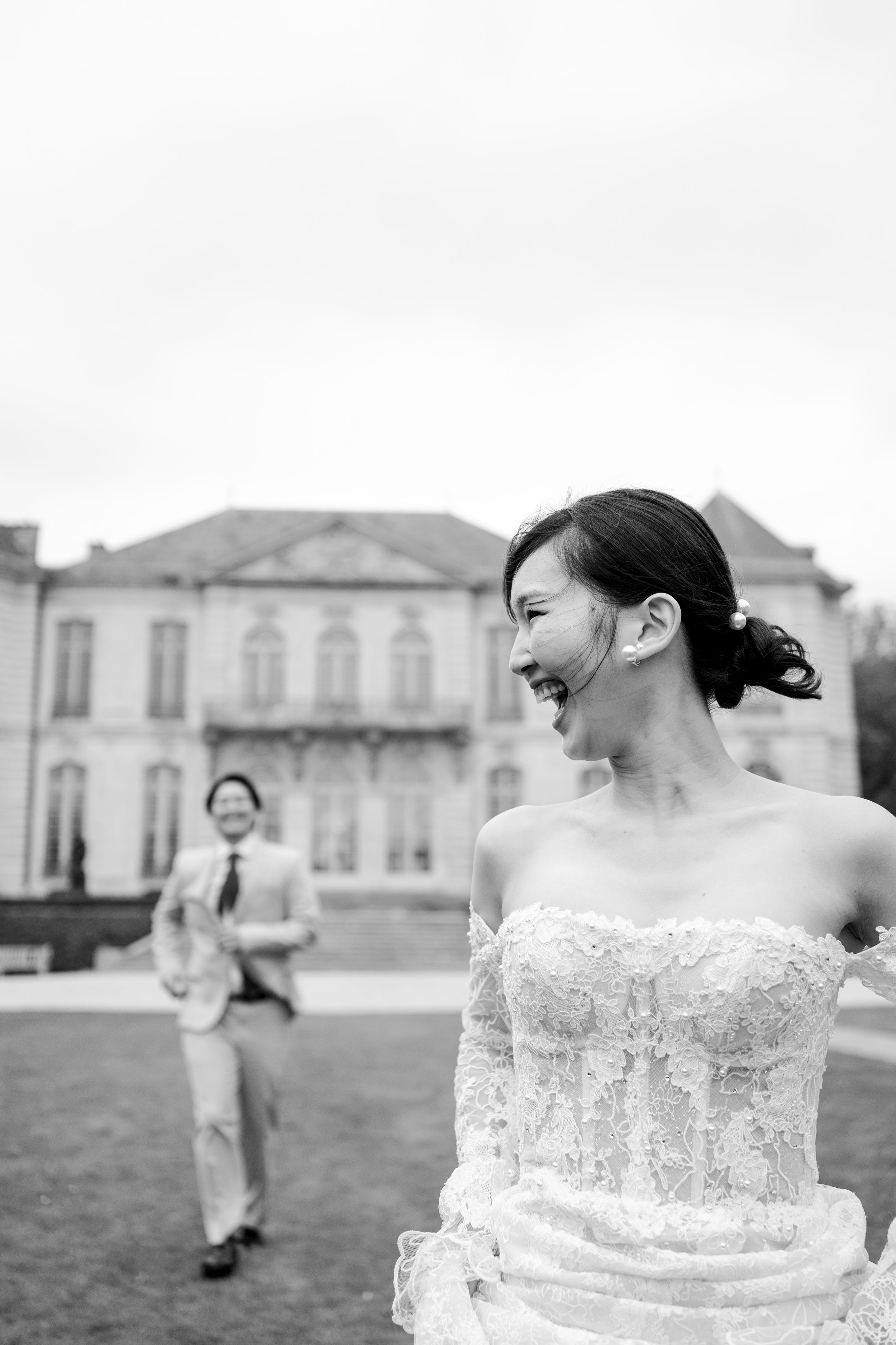Black and white photo of a laughing bride in lace gown. Paris running wedding photos. PAris cinematic wedding photography. Paris film photos
