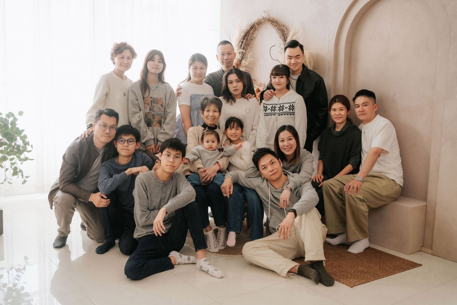 A collage of group photos showing people posing together in a bright studio setting with white walls and wooden floors.一組拼貼照片，照片中人們在明亮的攝影棚內擺