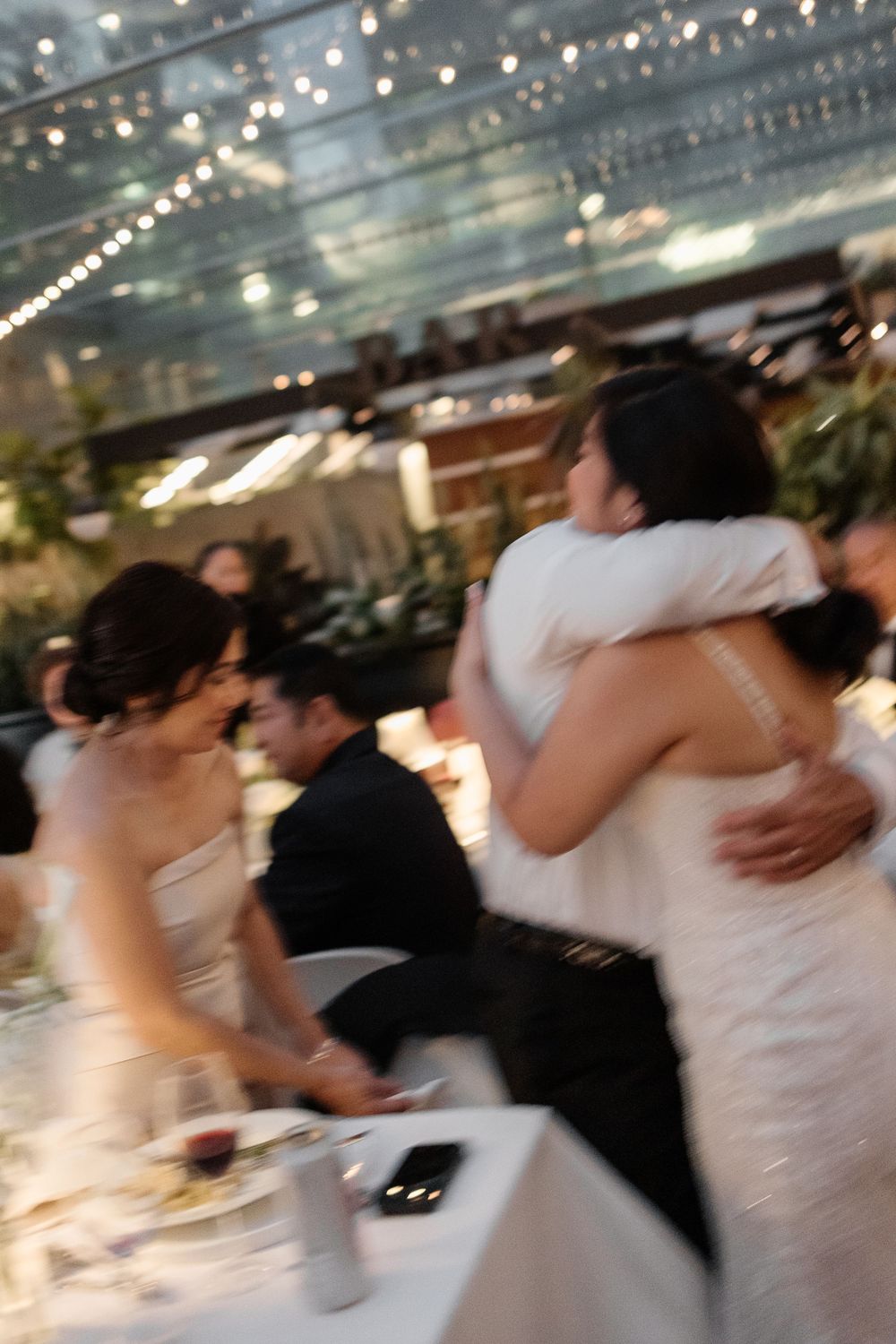 Bride and groom share a warm embrace during their wedding reception in an elegant venue.