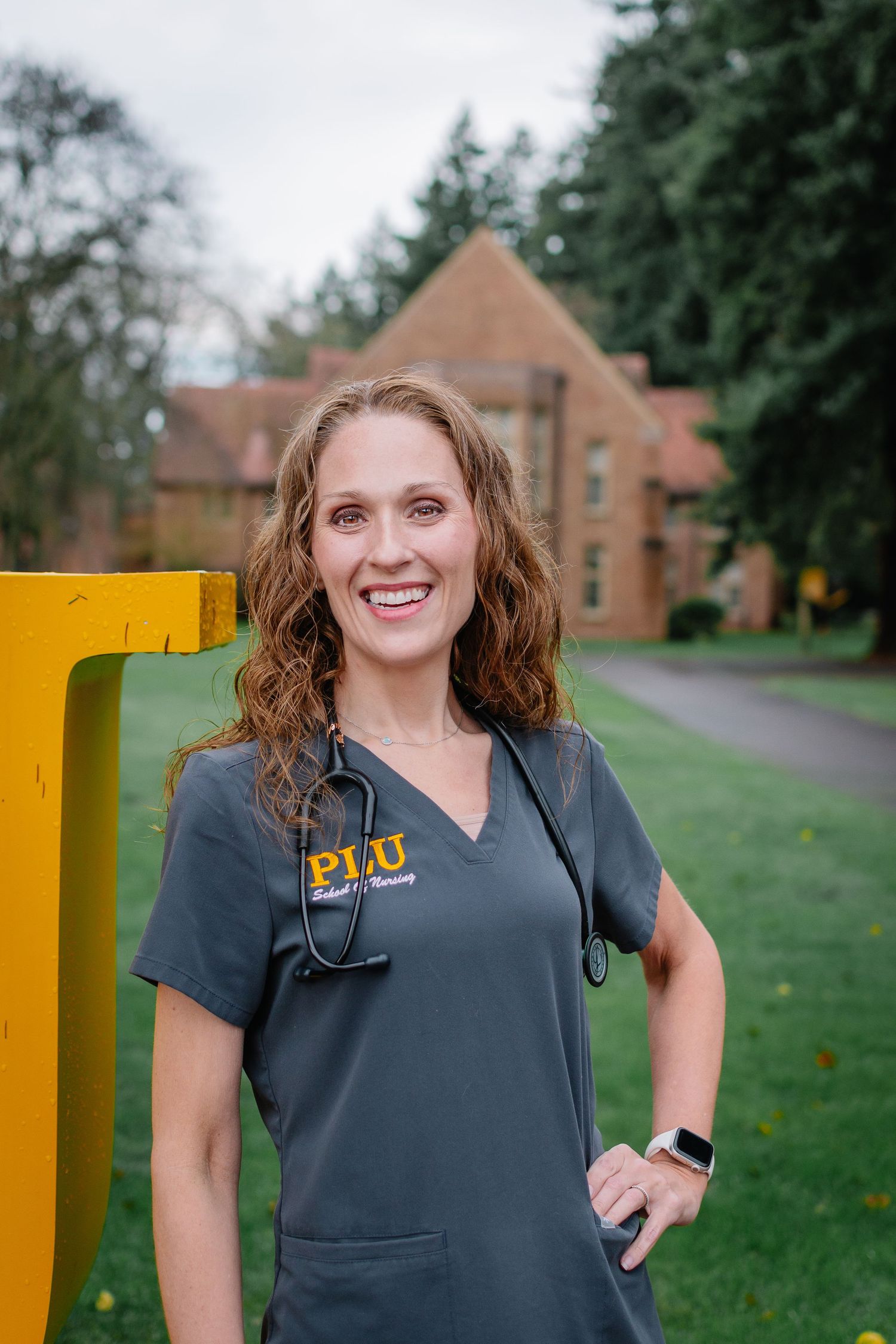 Nursing graduate portrait in scrubs with stethoscope during graduation session in Tacoma, Washington.