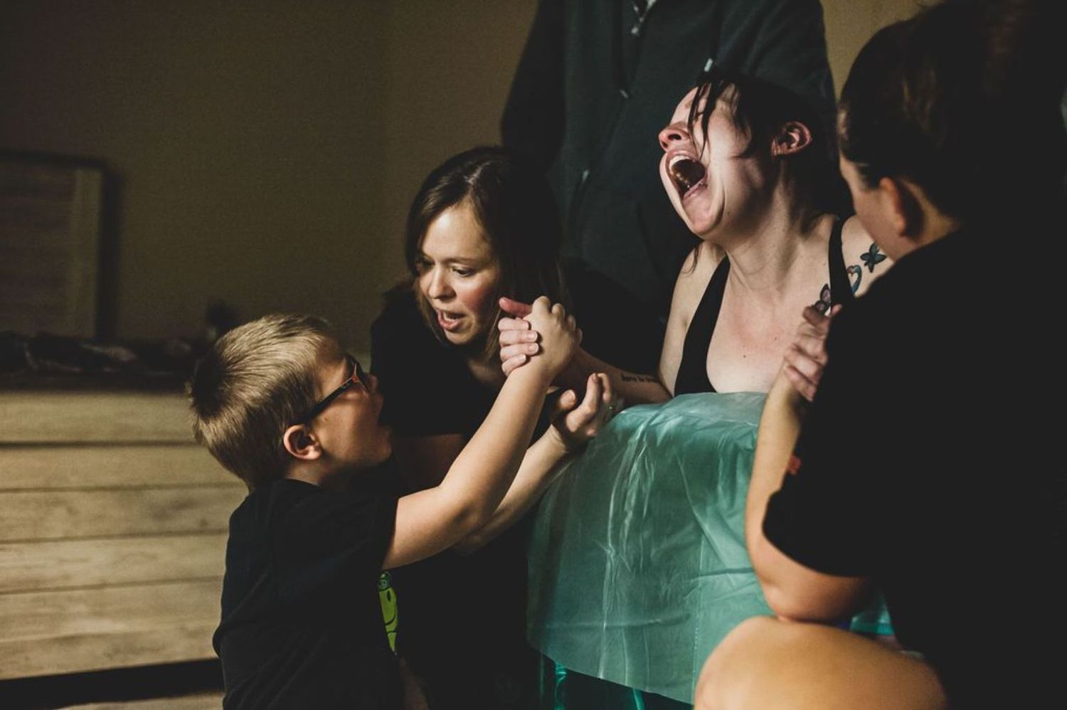 An emotional moment shared between birthing support team members during labor.