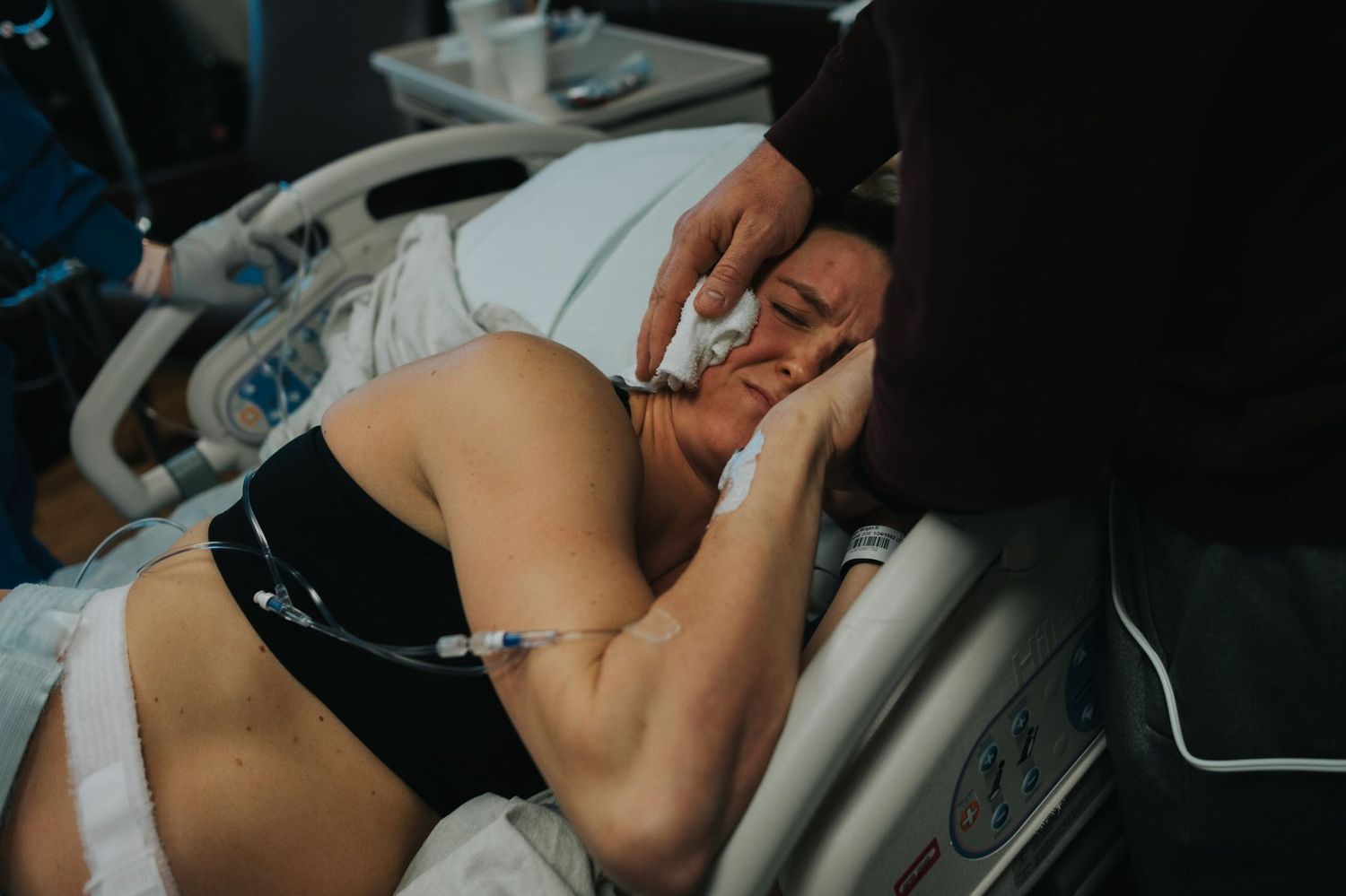 Close-up photo showing emotional support during labor in medical setting.