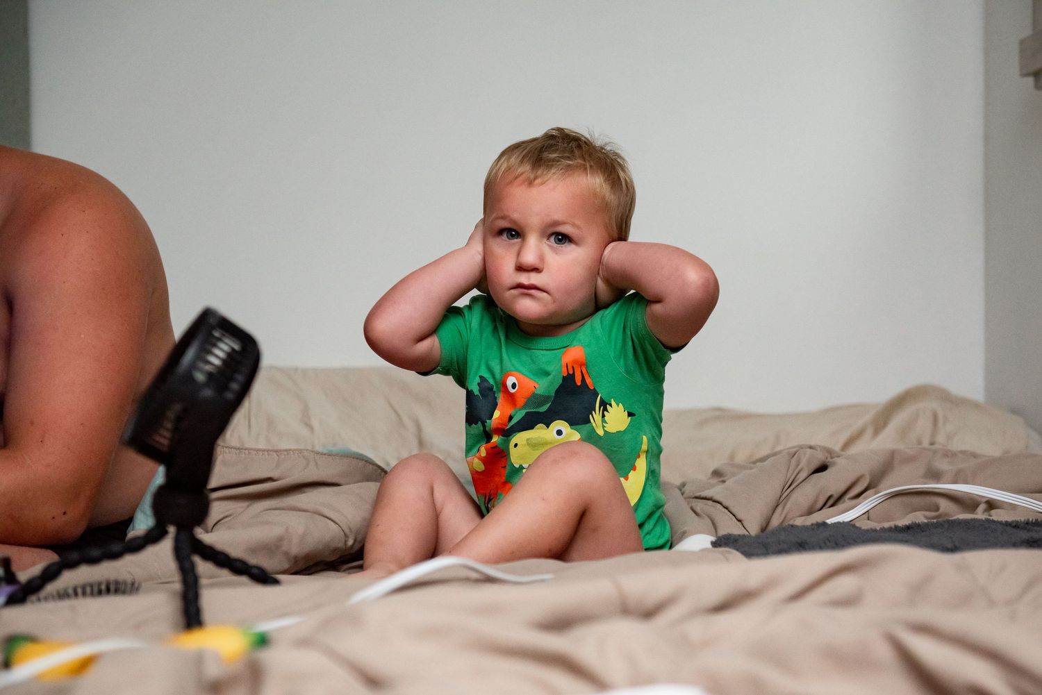 A series of connected photos showing a baby in a diaper playing and posing on a bed with white sheets.