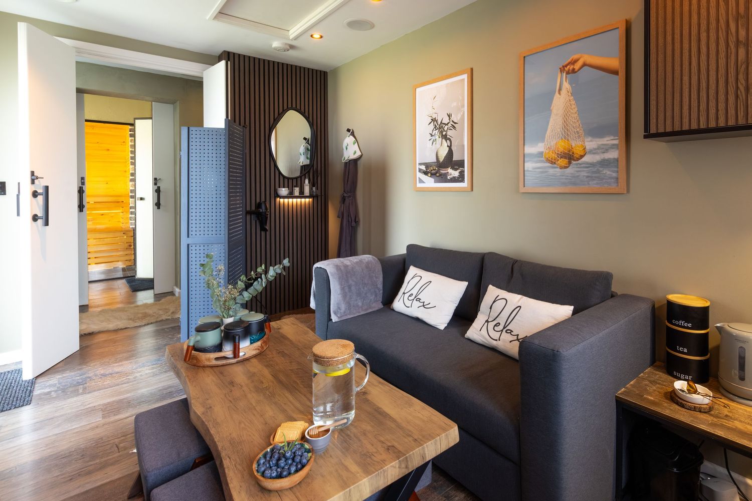 Spa relaxation room in Bedfordshire with grey sofa, coffee table and artwork, photographed for interior shoot.
