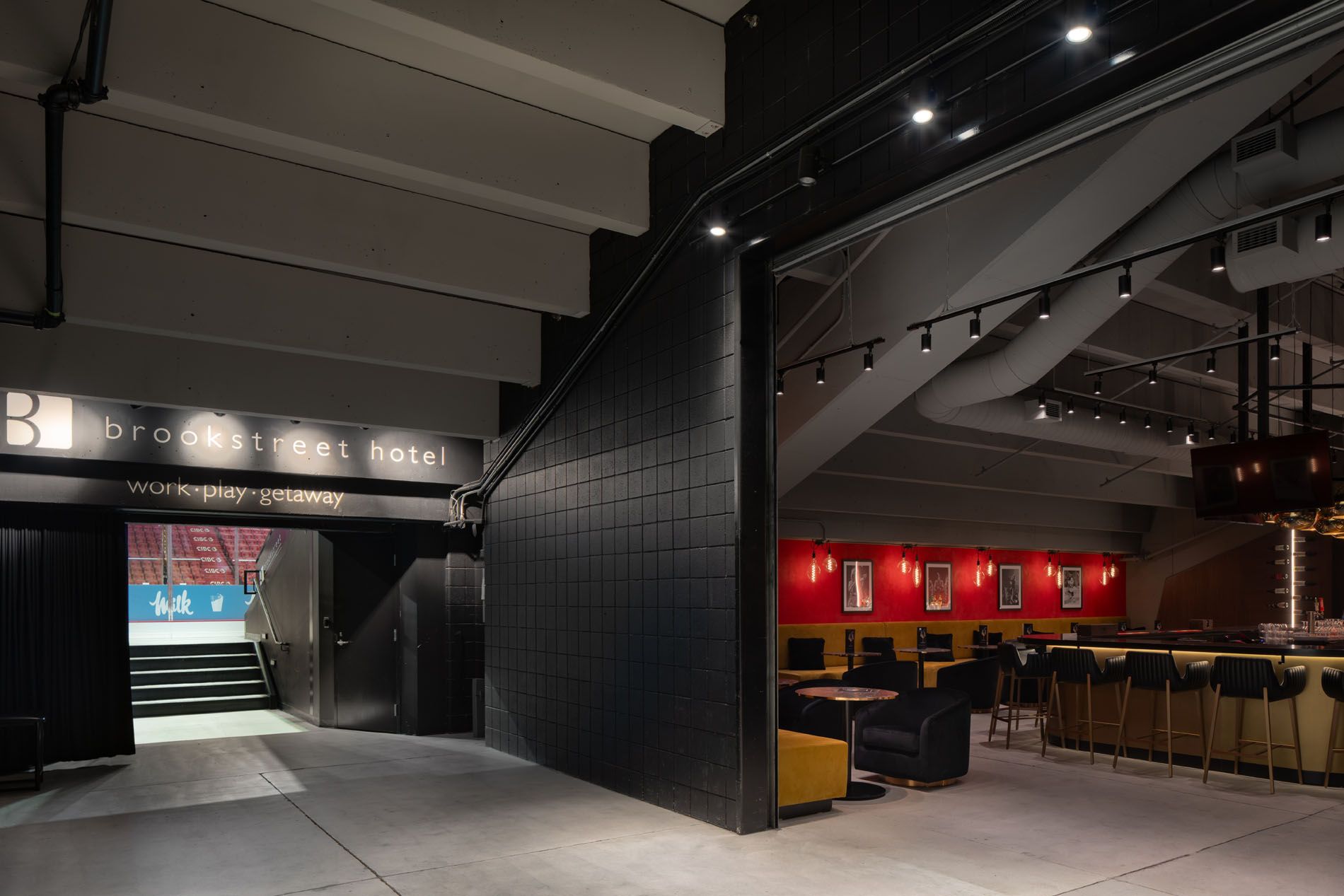Architectural transition shot from arena concourse to Brookstreet Lounge, featuring industrial textures and branded signage for J.L. Richard