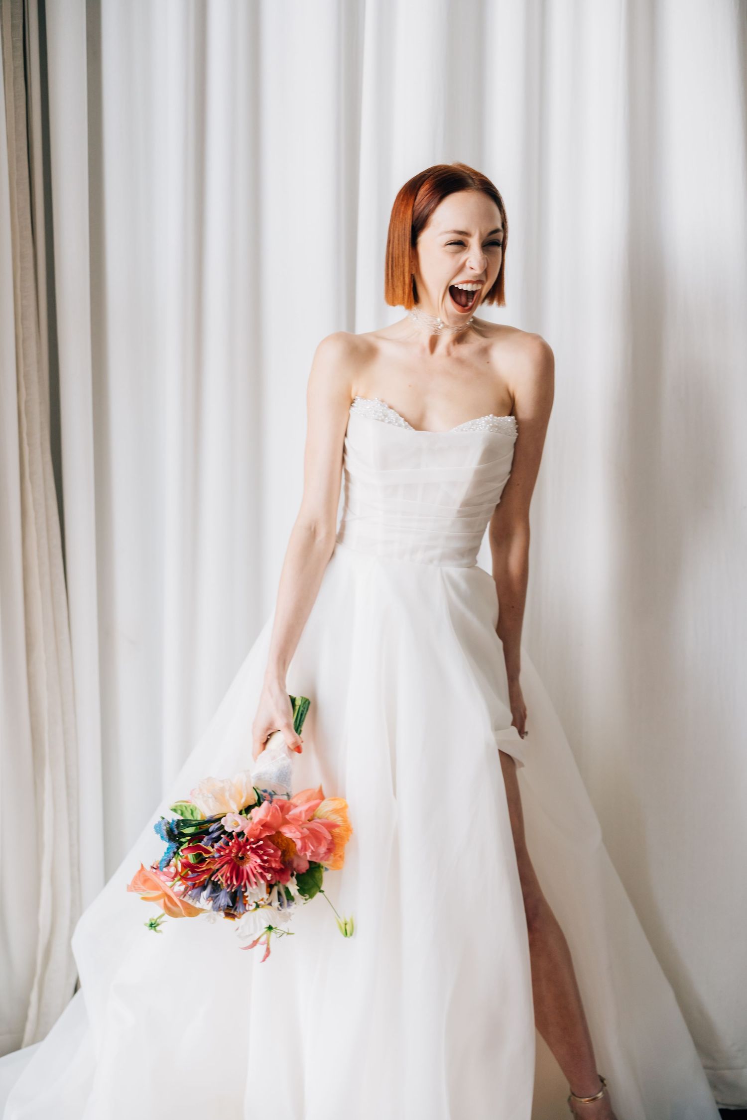 A bride in a white wedding dress and veil smiles while posing outdoors at City Park in New Orleans, Louisiana