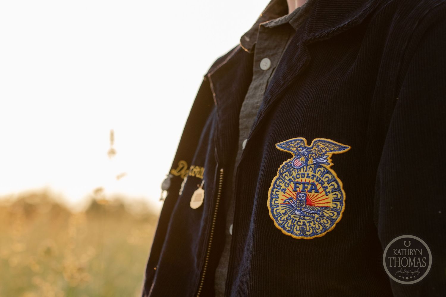 Close-up detail of FFA emblem patch on black graduation gown.
