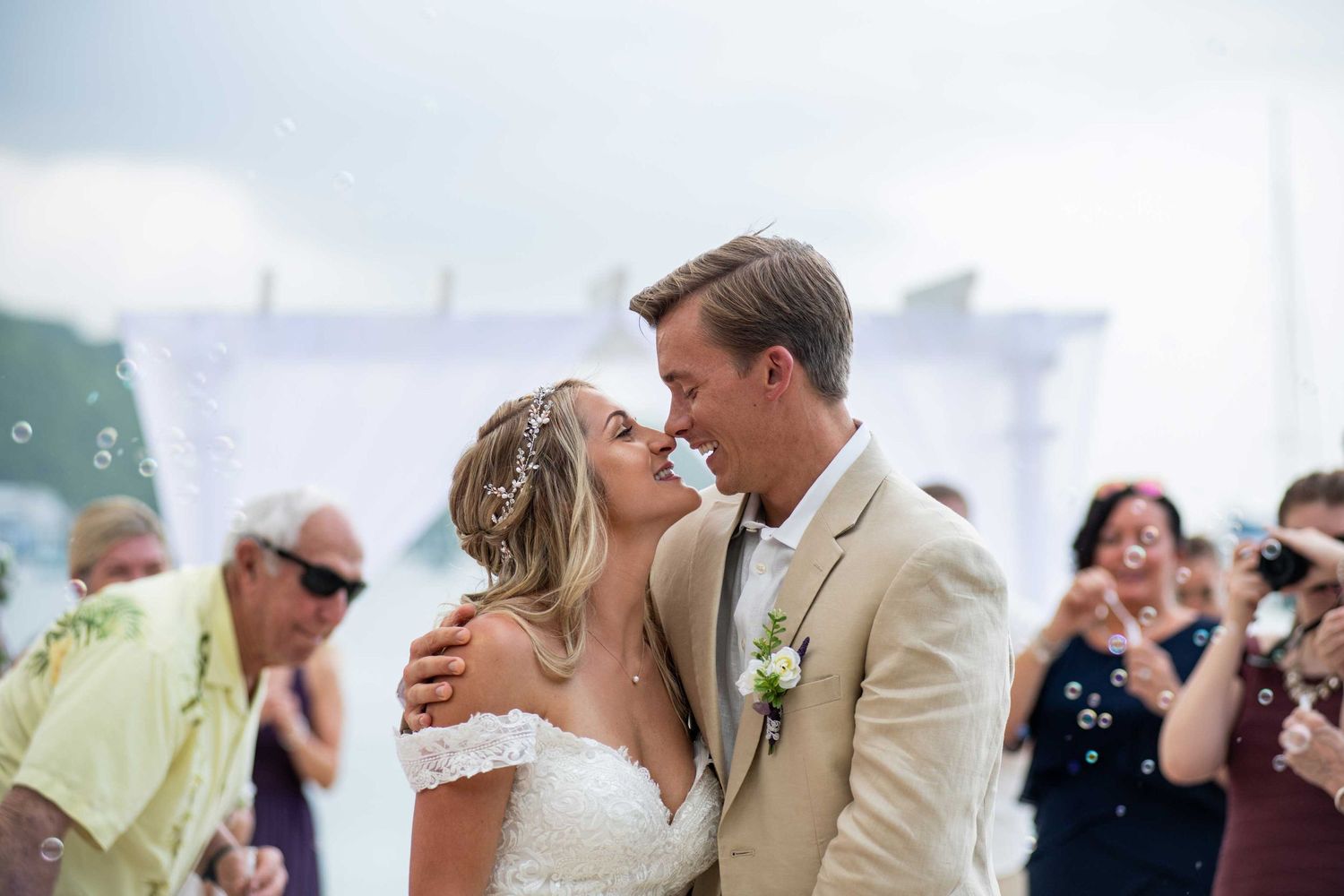 A newlywed couple shares an intimate moment during their beach wedding celebration.