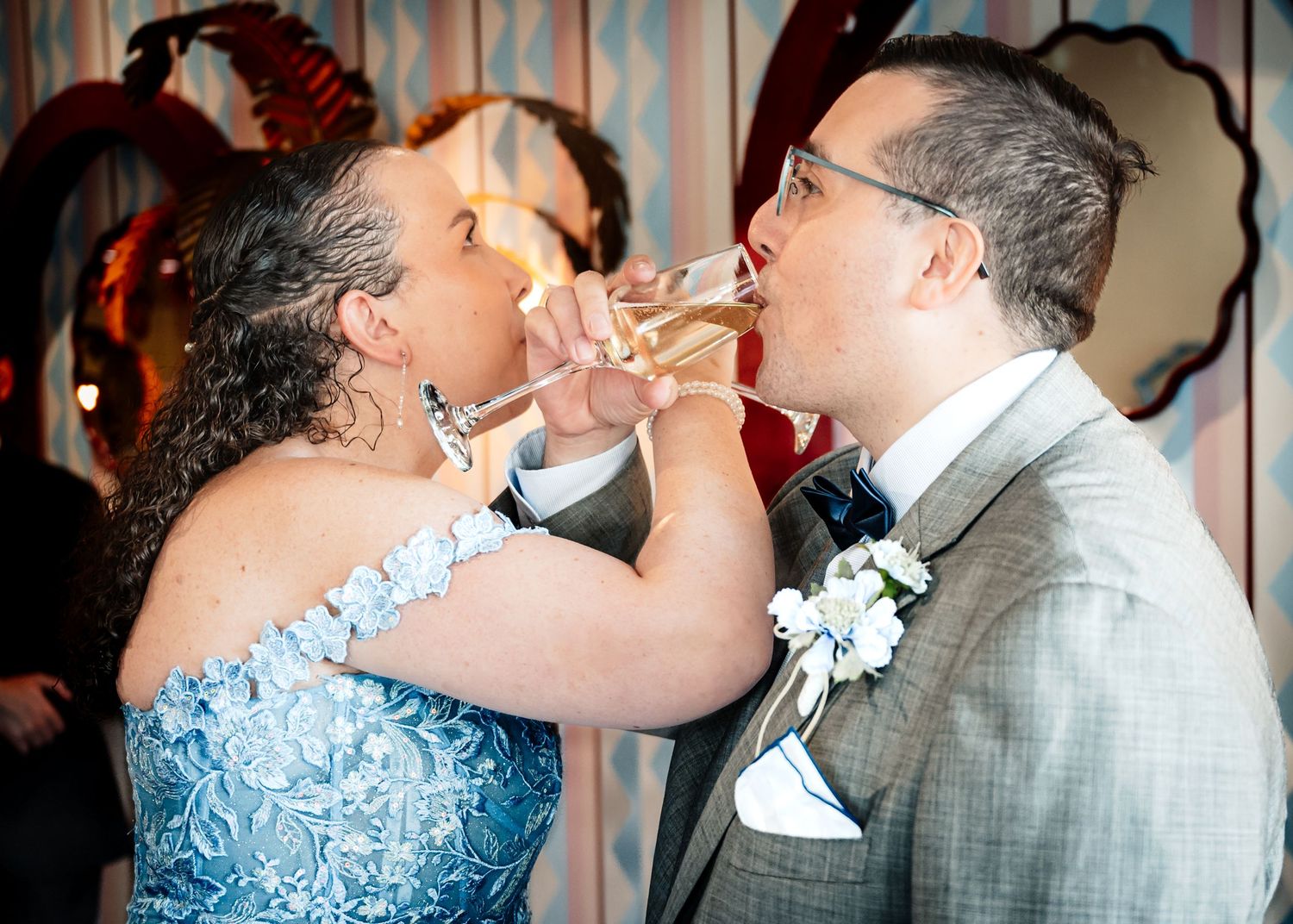 Couple in formal attire sharing wedding cake at their reception.