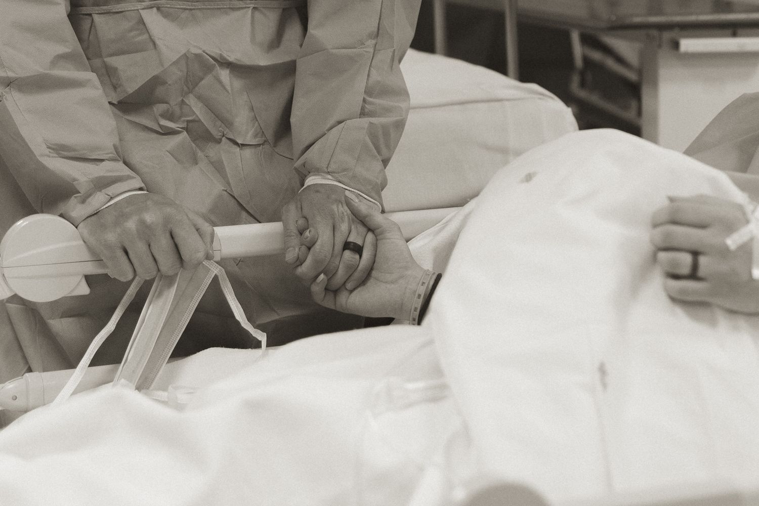 Medical professionals in protective gear perform a surgical procedure on a patient in an operating room.