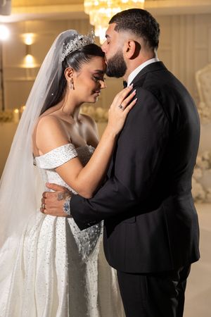Intimate moment between newlyweds during their first dance in elegant ballroom setting.