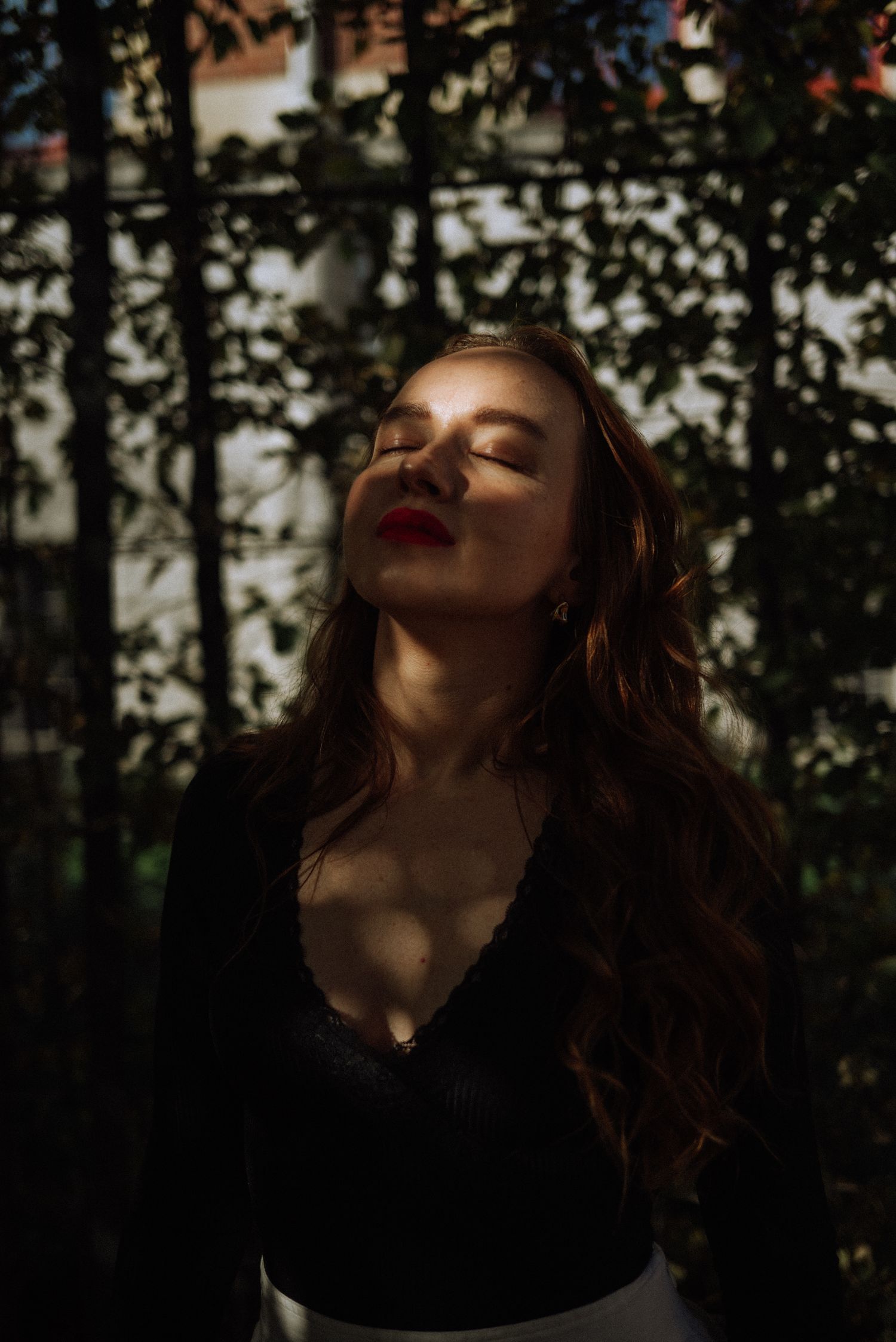 Romantic portrait of a woman with shadows on her face in an Amsterdam park.
