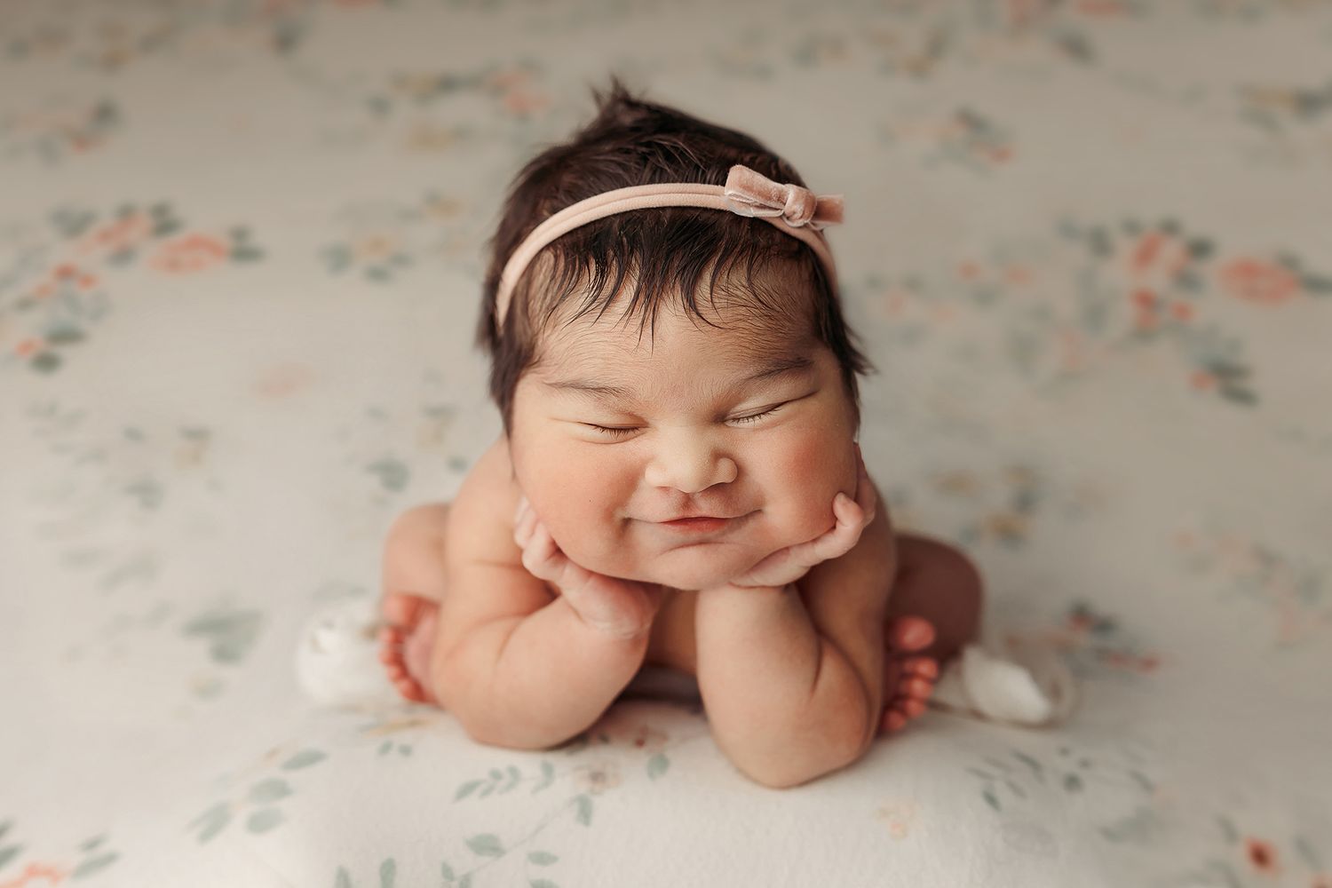 A newborn baby sleeping peacefully on a floral patterned blanket in various poses.