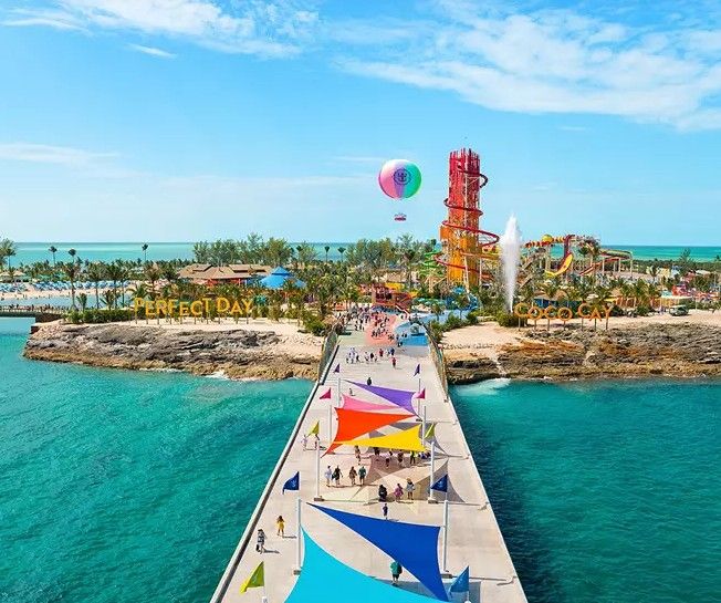 Aerial view of pristine turquoise waters and lush green islands in a tropical paradise with white sandy beaches.
