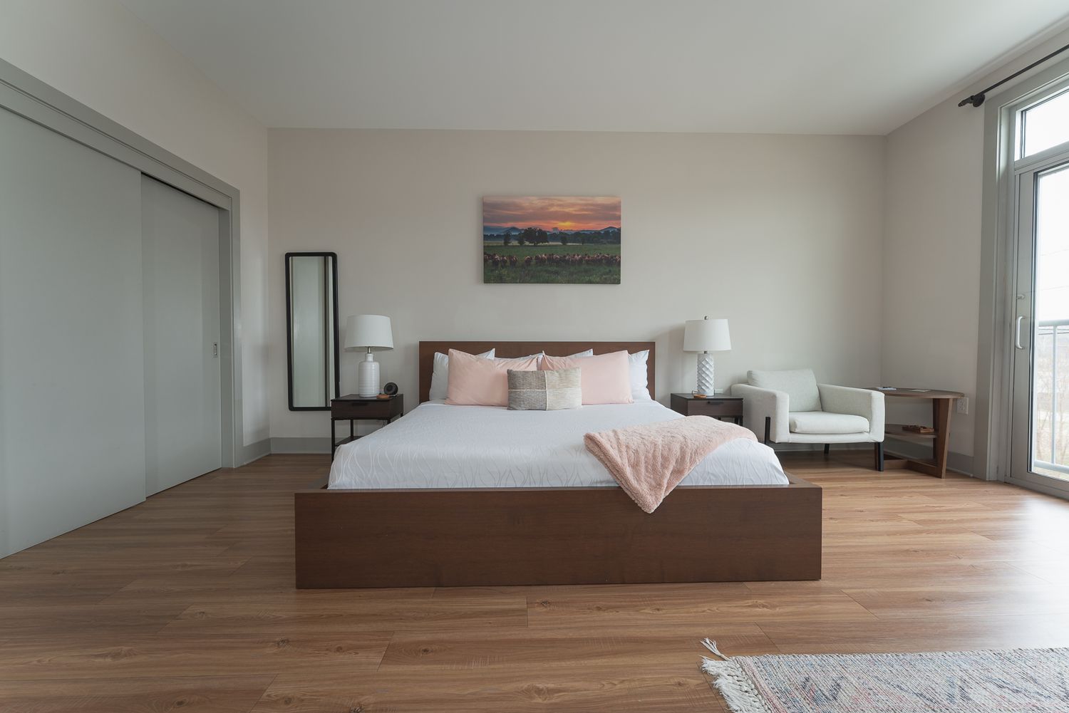 An interior shot of a king suite showing a king sized bed and side chair at a vacation rental complex in Asheville, NC.