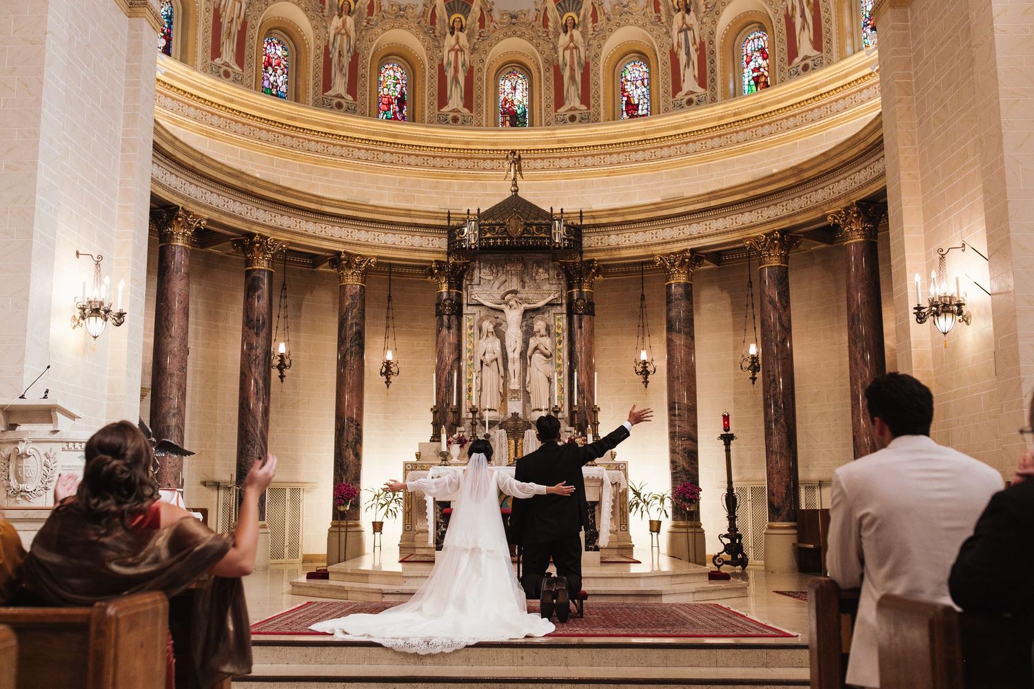 A panoramic view of an elegant wedding ceremony inside a grand domed church with ornate classical architecture and decor.