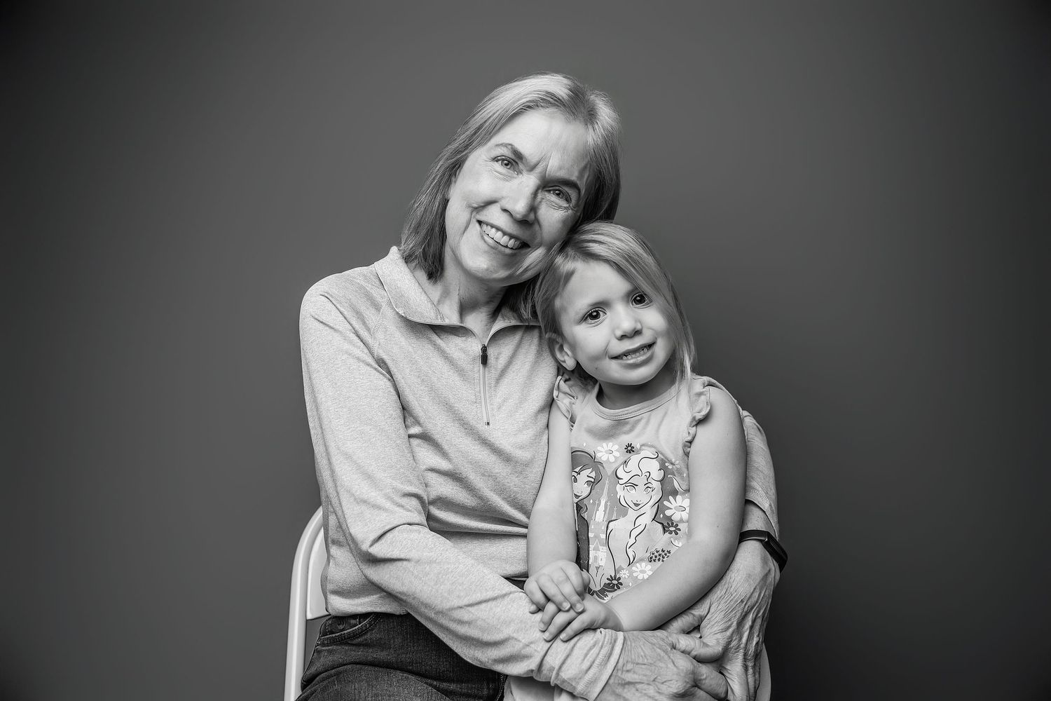 A series of four black and white photos showing warm embraces between parent and child in a studio setting.