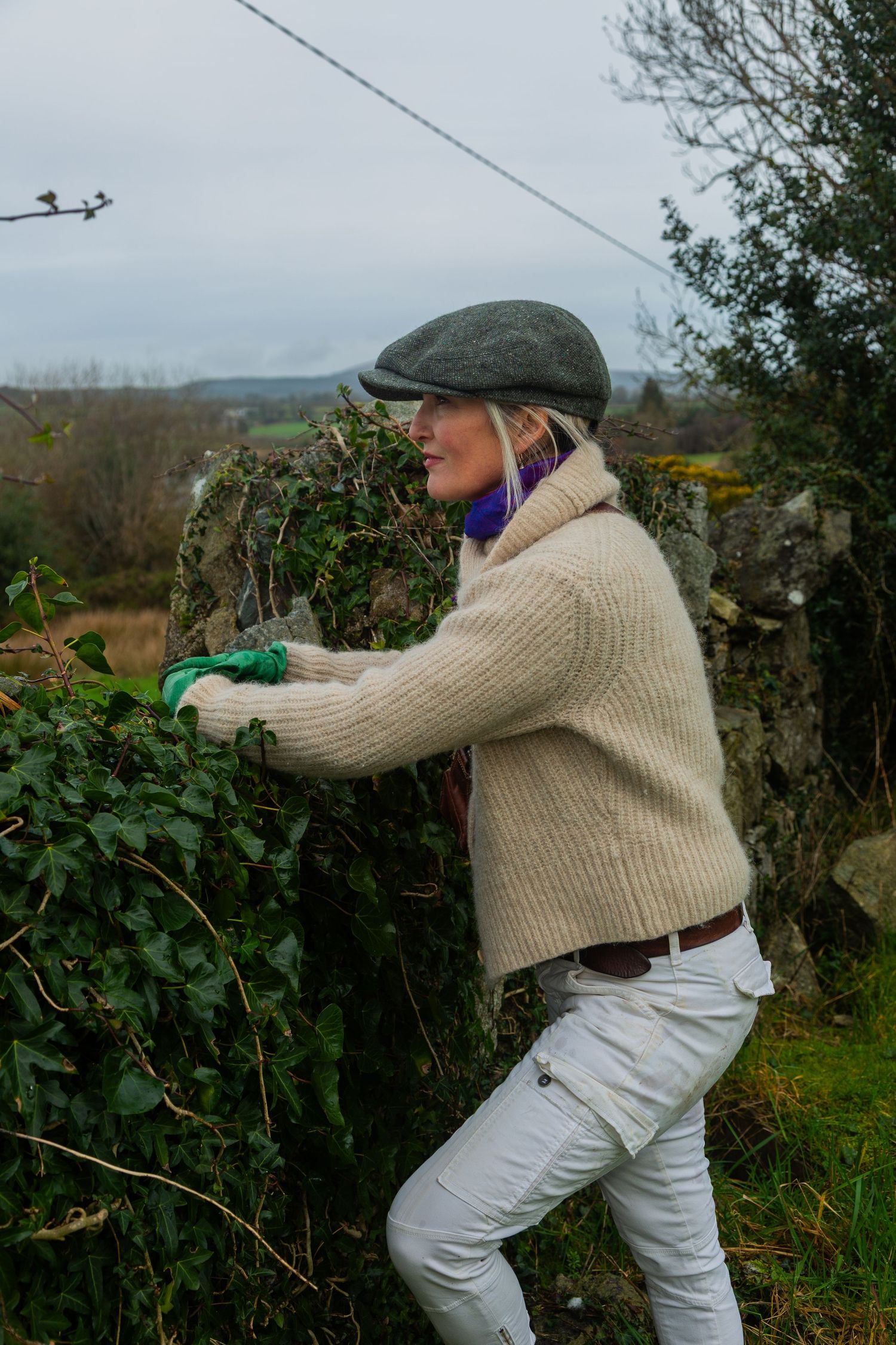person enjoying the stunning views of wicklow against a rustic stone wall.