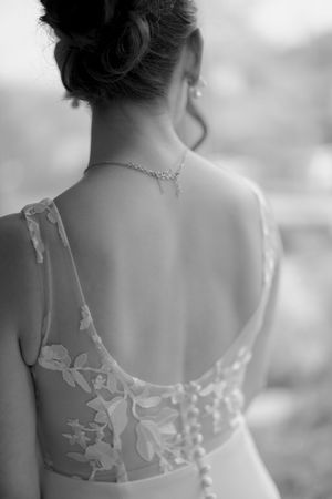 Close-up detail shots of a wedding dress back showing delicate white lace applique against sheer fabric.