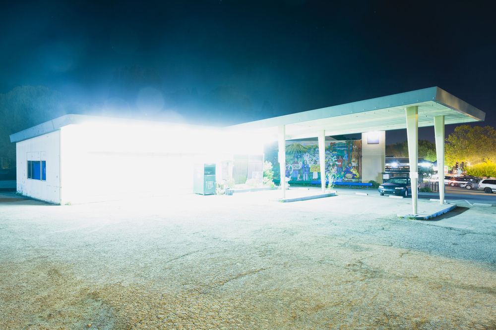 Wide angle view of brightly lit commercial building facade at night.