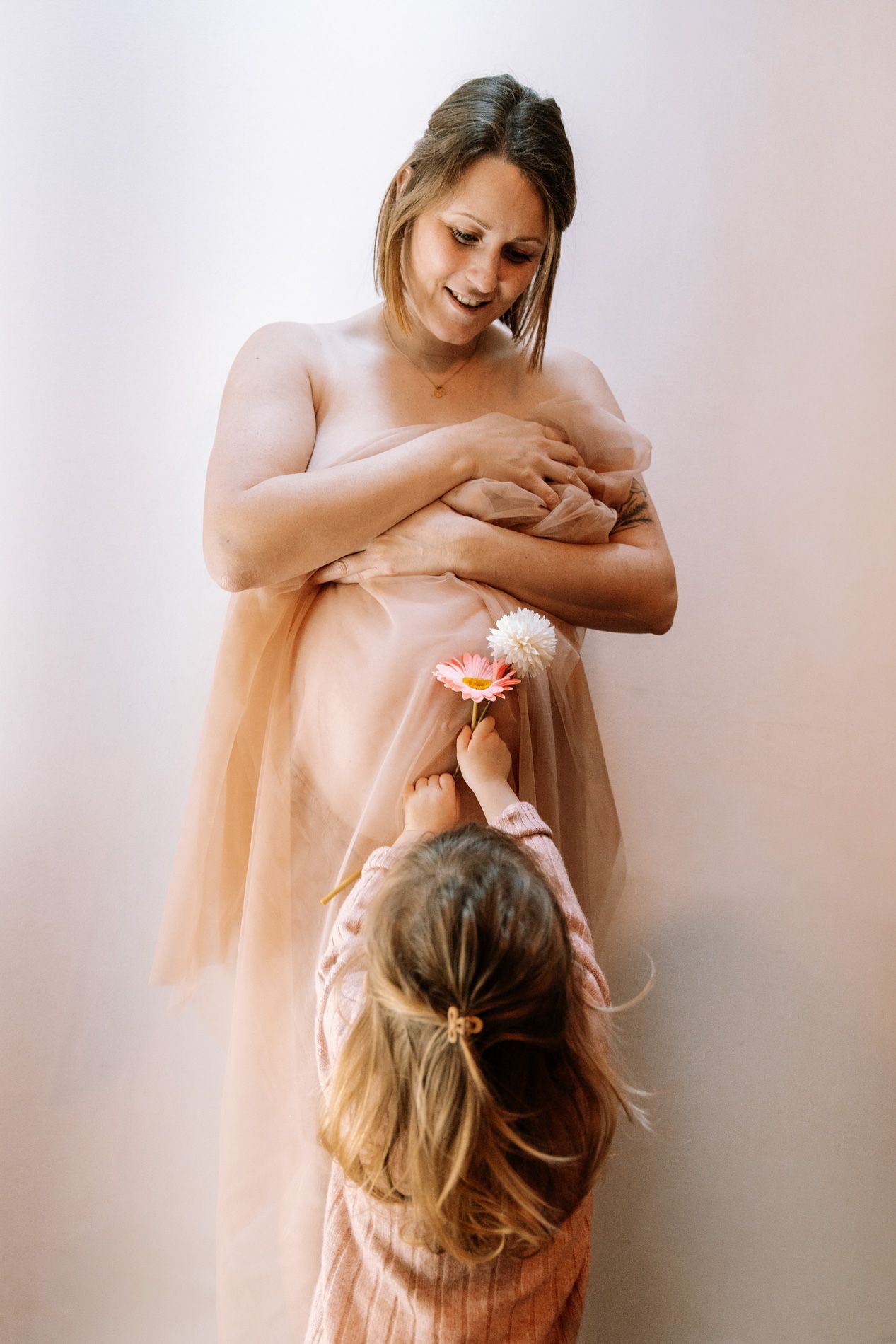 A series of soft, ethereal photos showing tender moments between parent and child in muted peachy tones.