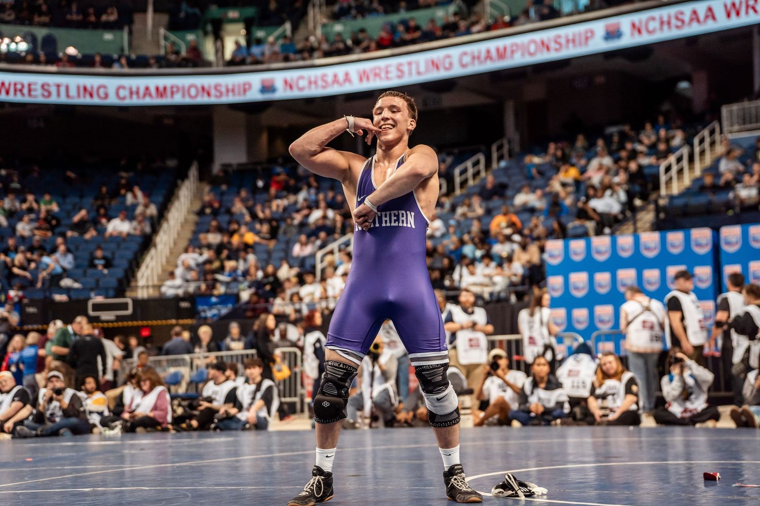 High school wrestlers compete in intense matches during a wrestling championship tournament at an indoor arena.