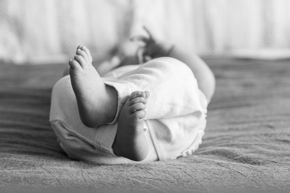A black and white photo showing a baby's feet at her newborn session.