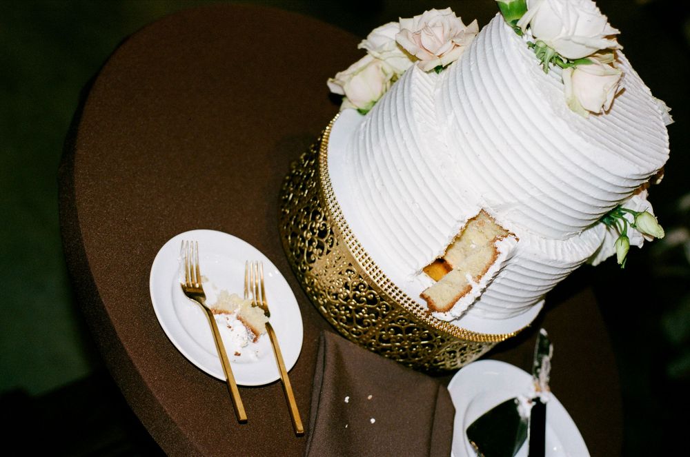 Elegant white wedding place settings with gold cutlery and floral decorations on a dark table.