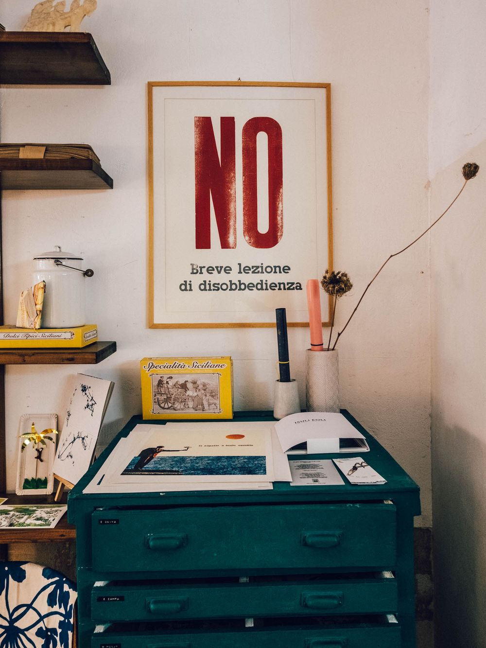 Interior workspace with drafting tables and art supplies in a studio setting with red lettering on the wall.