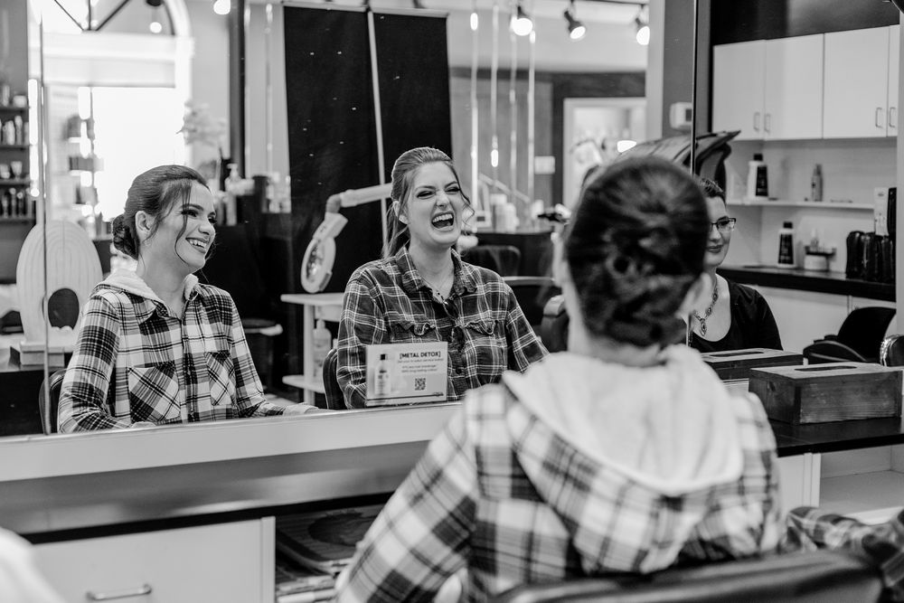 Bride sitting and laughing with her bridesmaid in the morning in Kitchener, Ontario.