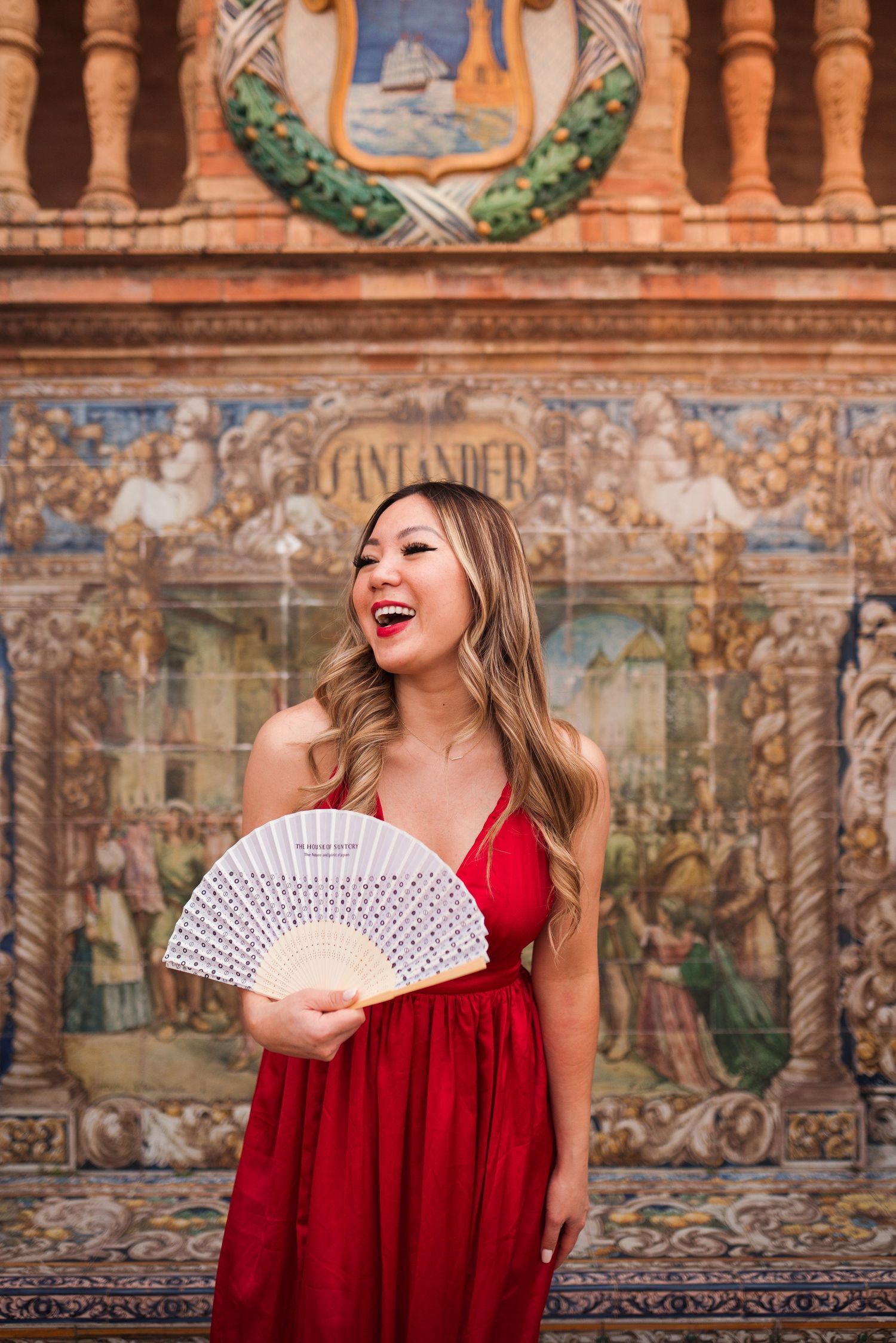 Woman in white outfit poses at Plaza de España with ornate architecture and patterned ground.