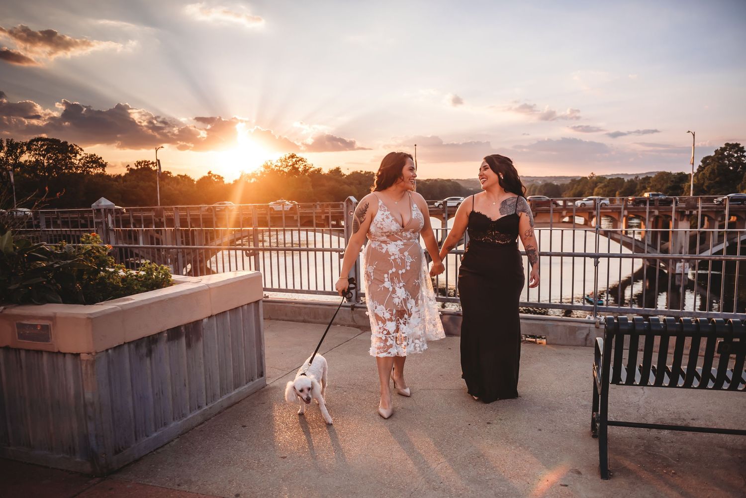 People enjoying a stunning sunset view from a waterfront balcony with golden light illuminating the scene.