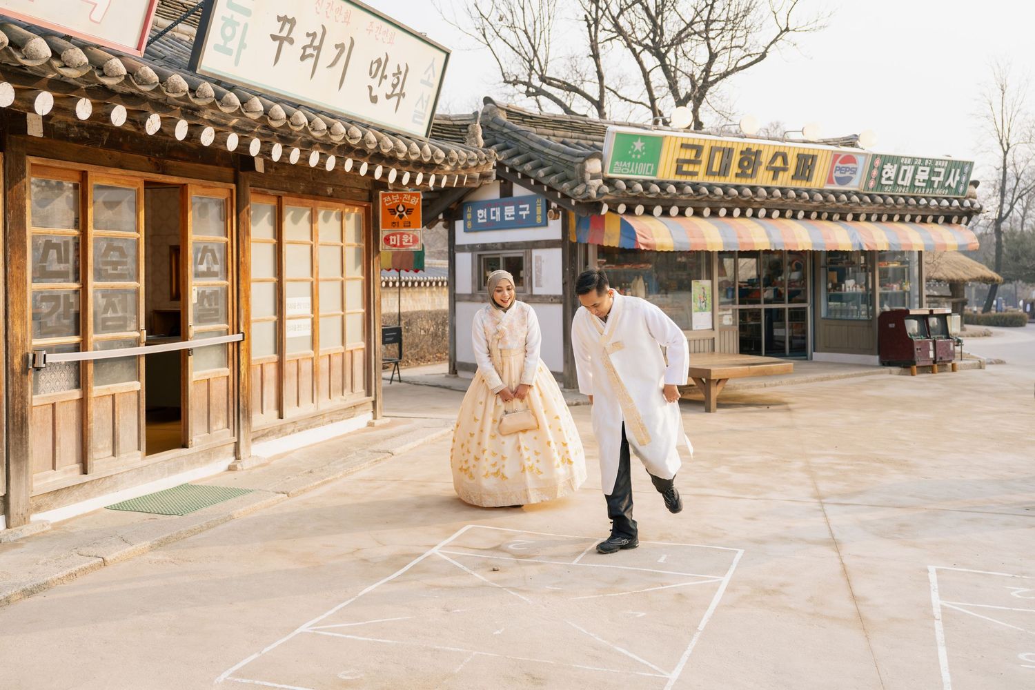 A panoramic view of traditional Korean hanok buildings with wooden architecture and tiled roofs along a street.
