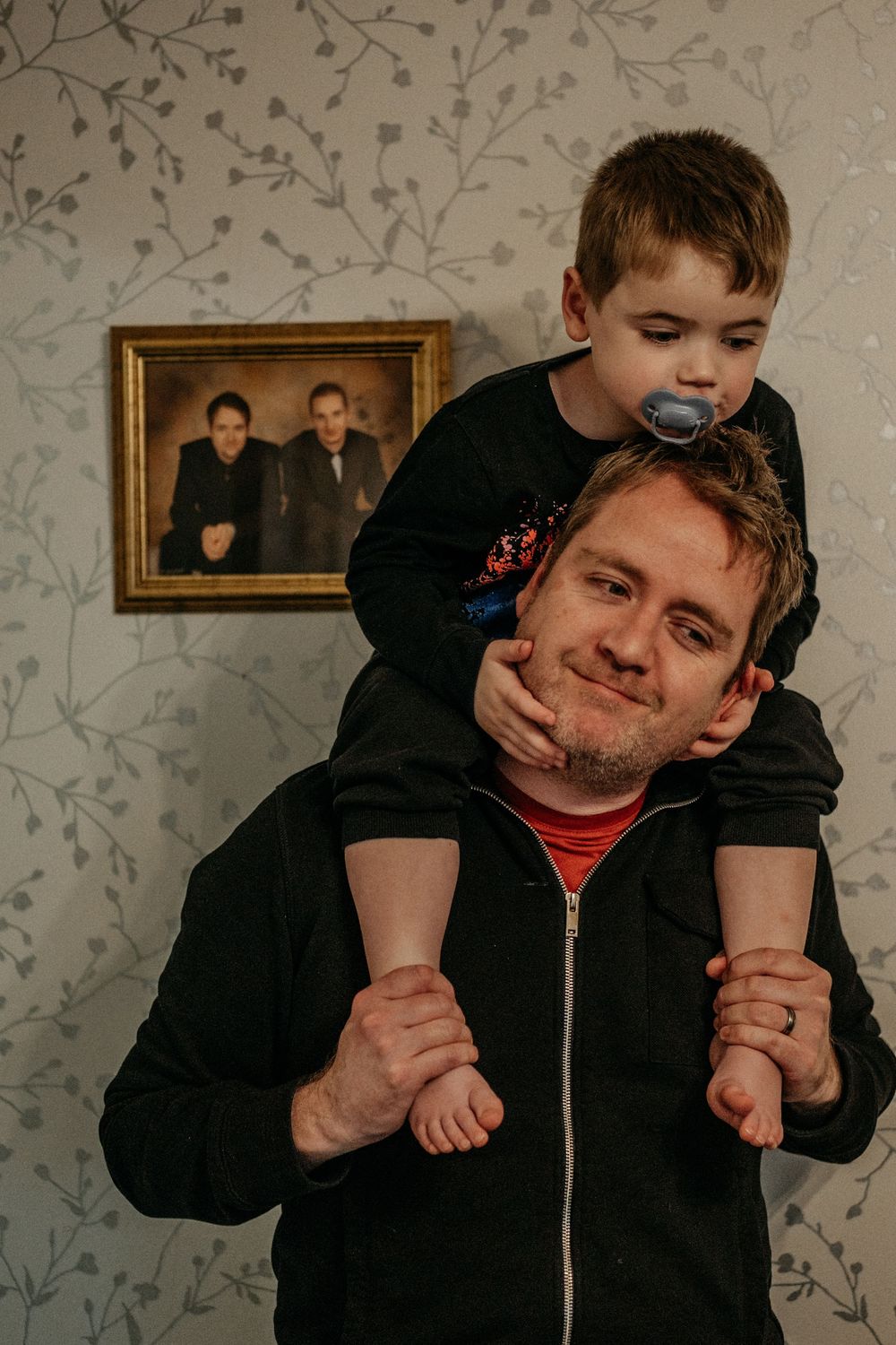 Parent carrying child with autism on shoulders, disability-inclusive family photography Whitley Bay area