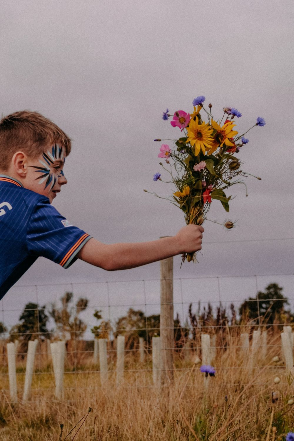 A boy with SEND hands a bouquet of flowers to his mom