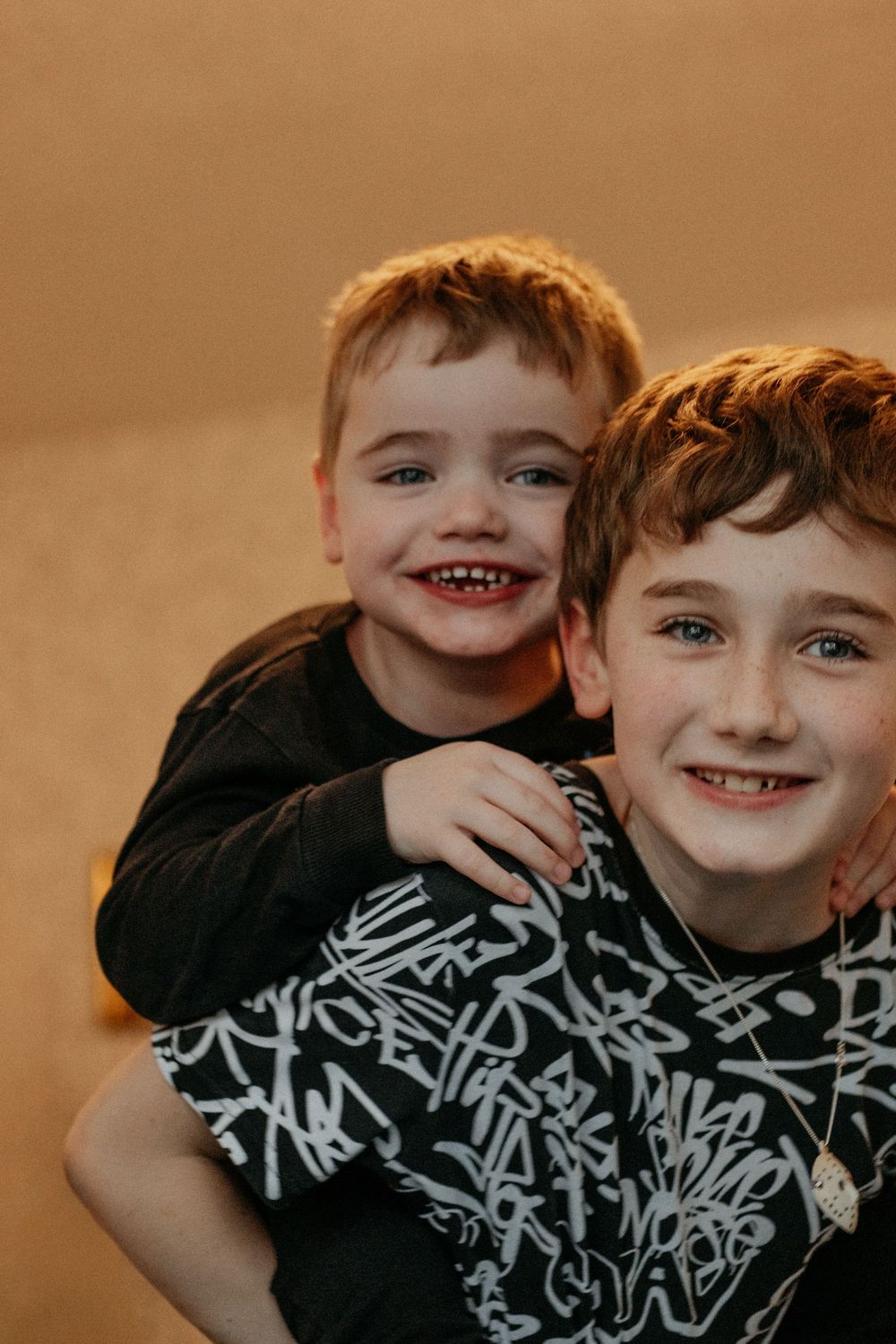 Two siblings with special needs embracing during family photo session, disability-inclusive photographer Newcastle