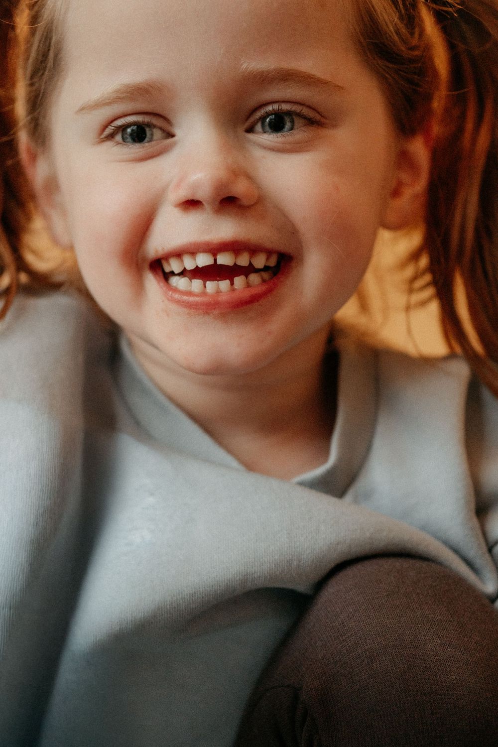 Joyful portrait of neurodivergent child smiling at camera, autism-friendly family photographer North East England