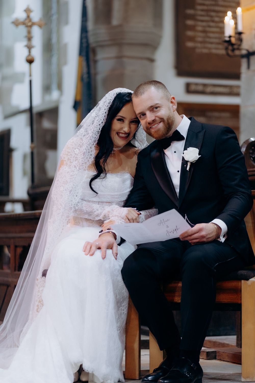 A joyful wedding moment captured in a church with candlelit ambiance and traditional decor.
