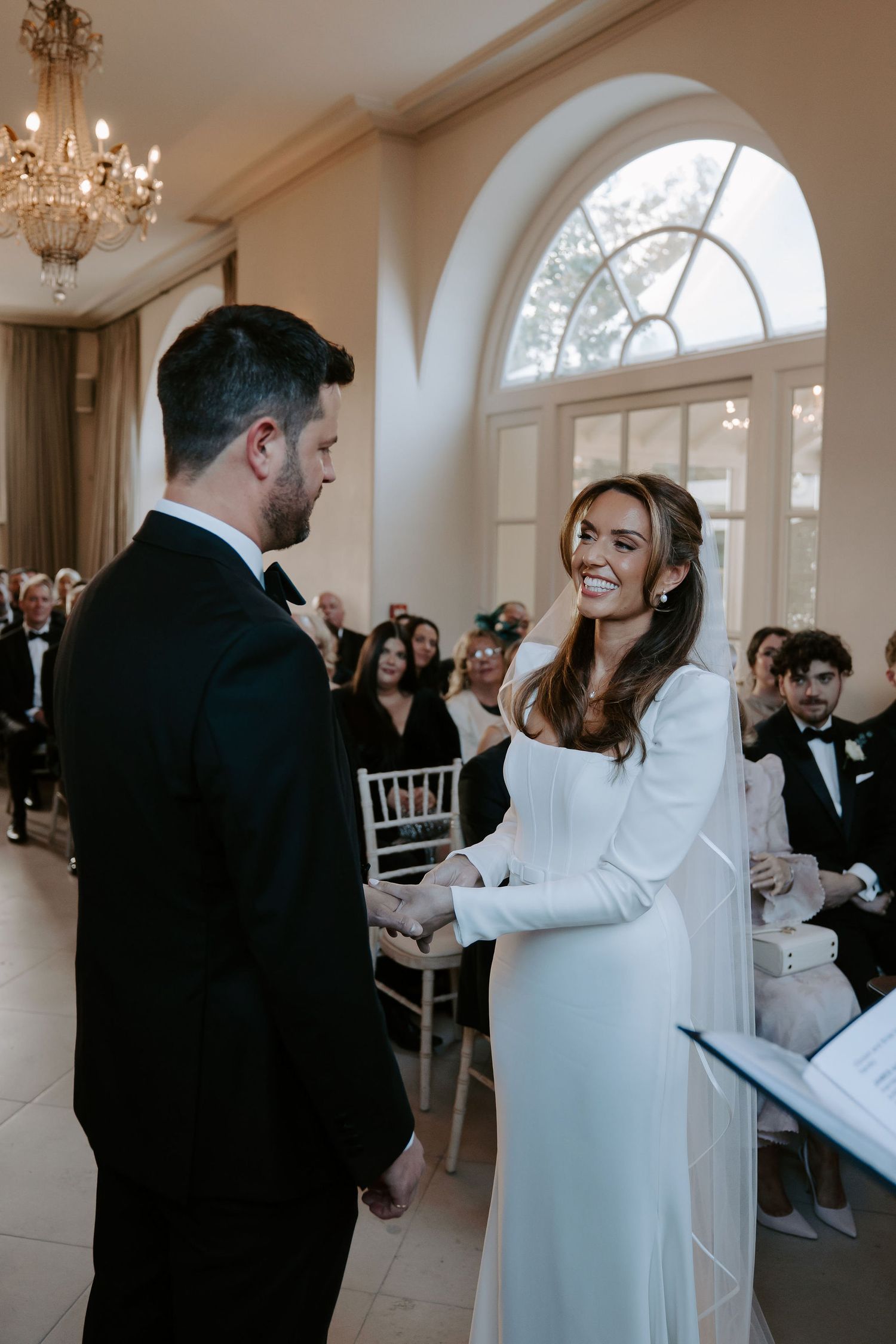 bride placing the ring on the grooms finger during exchanging of rings at Iscoyd park