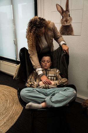 A series of five progressive photos showing someone sitting cross-legged on a dark floor with a bunny nearby.