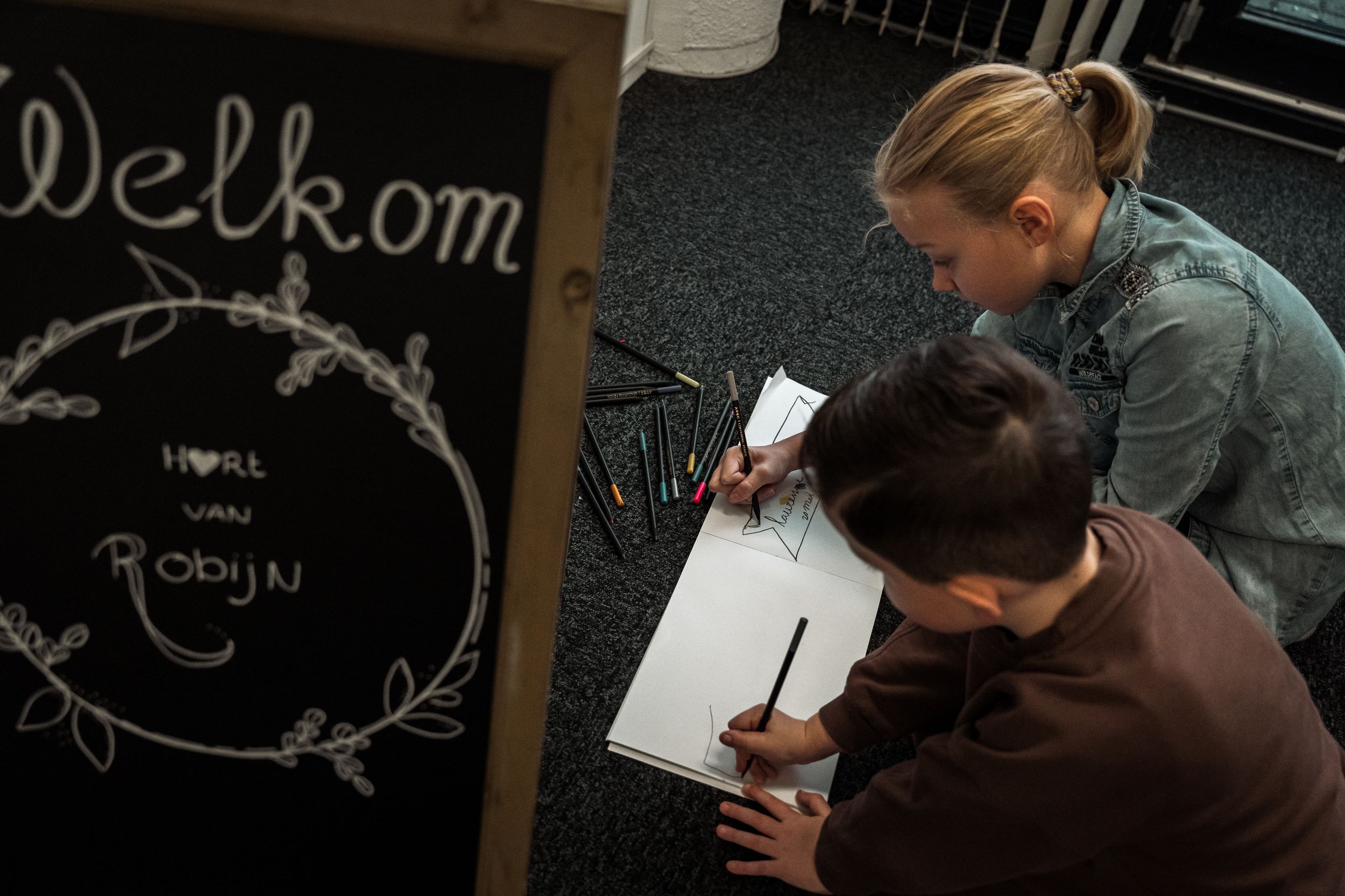 A chalkboard sign displays 'Welkom' in handwritten text with decorative elements.