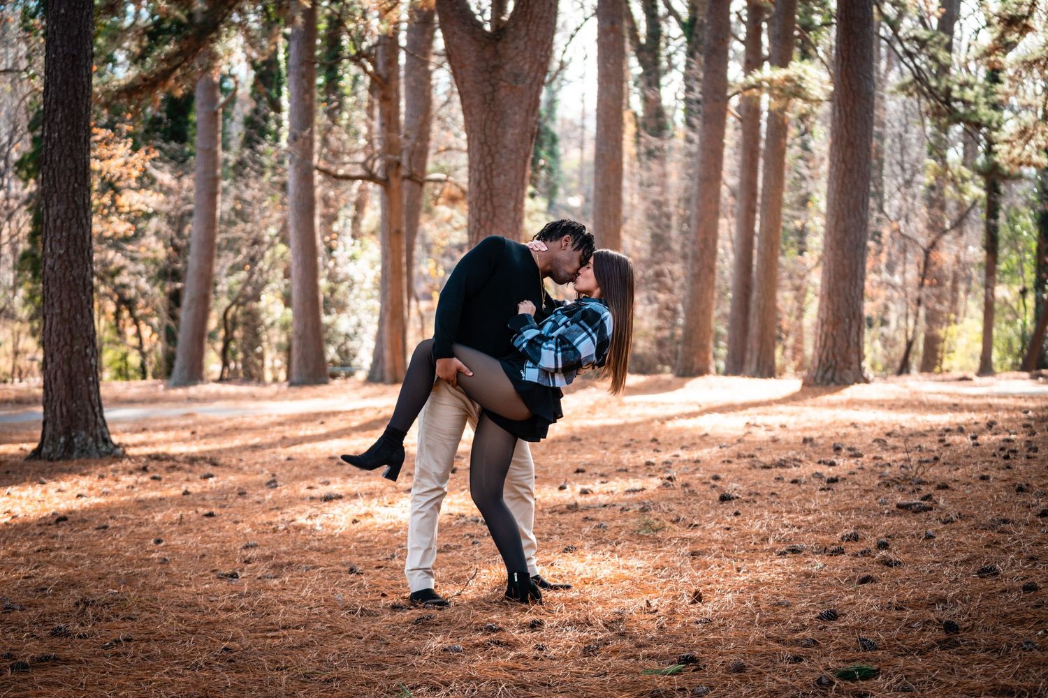 A couple in formal attire share an intimate dance moment at an evening event.