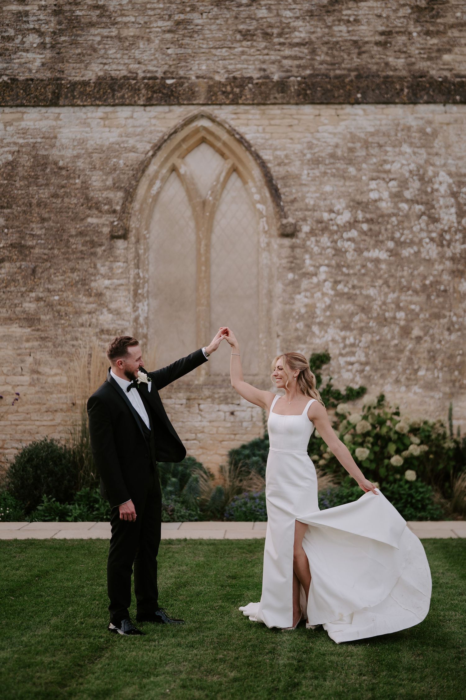 bride twirling with dress while holding grooms hand at ivy lodge in cirencester