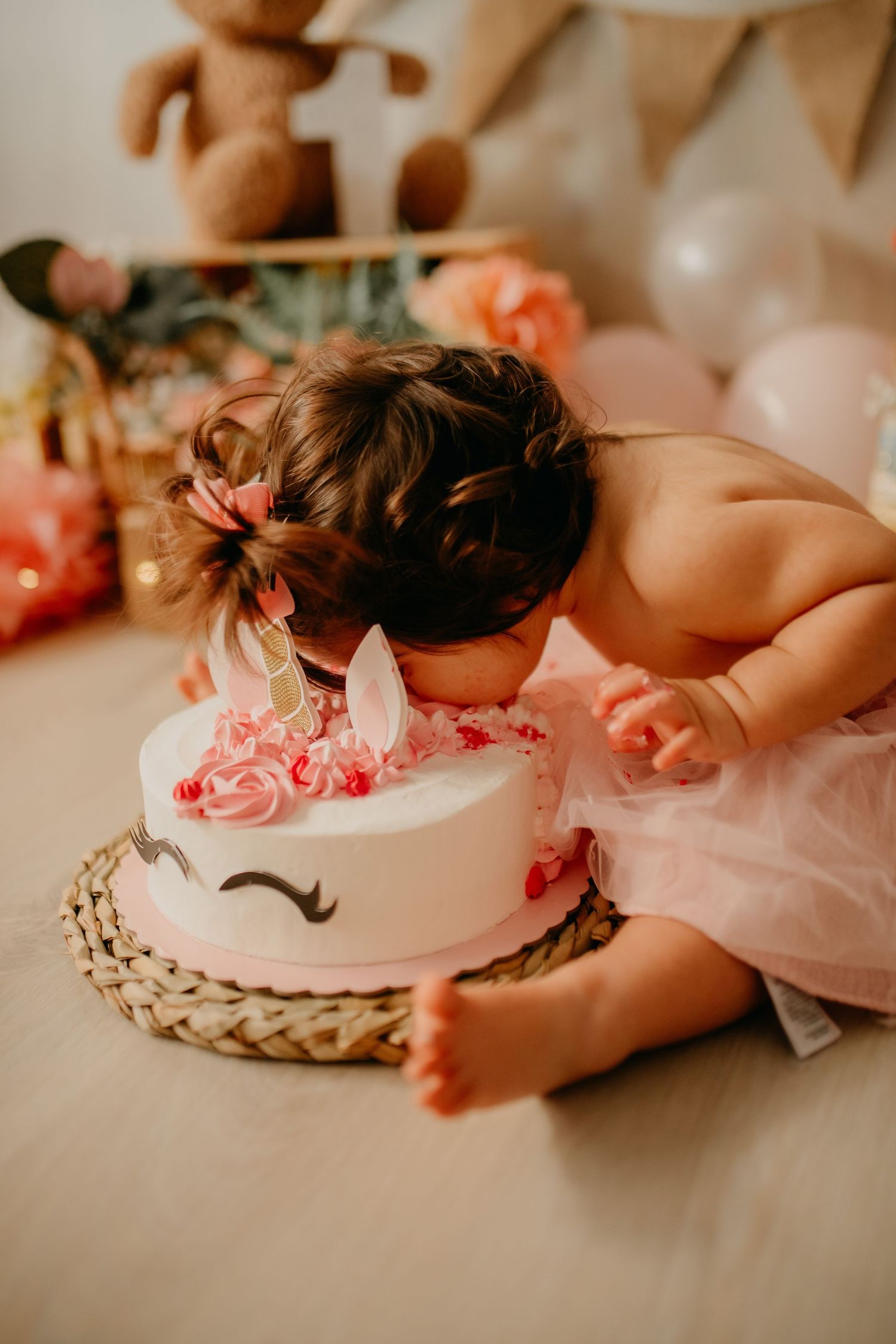Niña celebrando su primer cumpleaños en sesión smash cake en Tarragona comiendo pastel